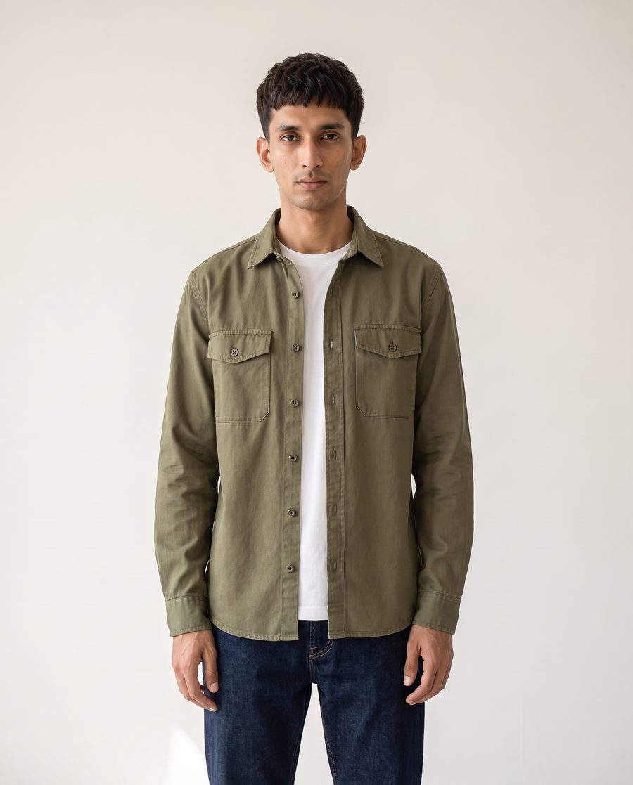 The same man in a fitted olive overshirt over a white tee, with a shorter crop
